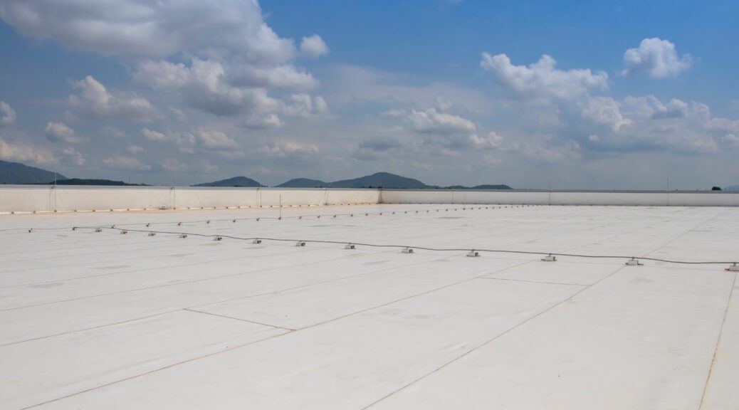 A commercial roof with PVC material on it against a blue sky.