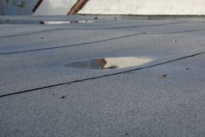 A puddle of ponding water on a commercial roof.