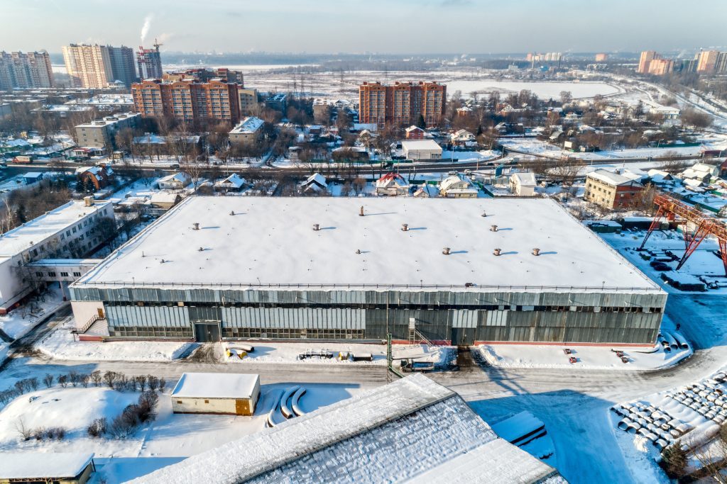 A wide- and high-angle view of a commercial warehouse covered in snow